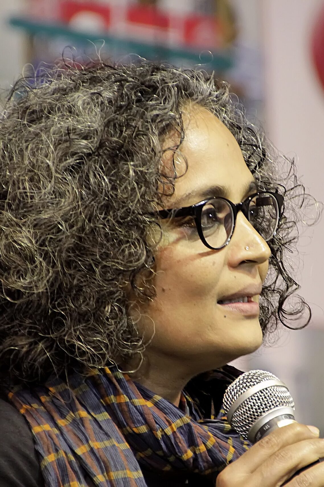 Arundhati Roy, Writer of Man Booker Prize for Fiction winning novel The God of Small Things (1997), speaks into a microphone. Photo credit: Vikramjit Kakati